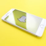 silver iphone on top of yellow wooden surface